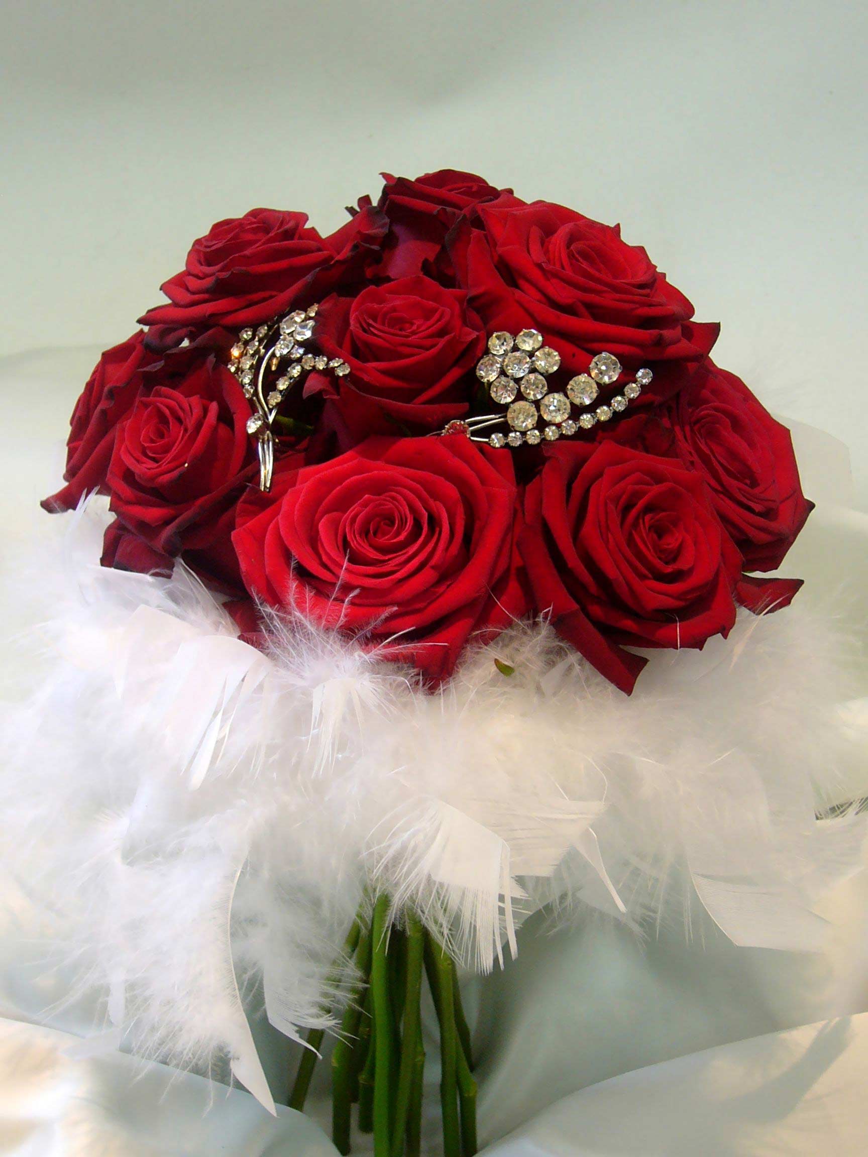 Hoa cưới cầm tay màu đỏ được kết từ hoa hồng và lông vũ