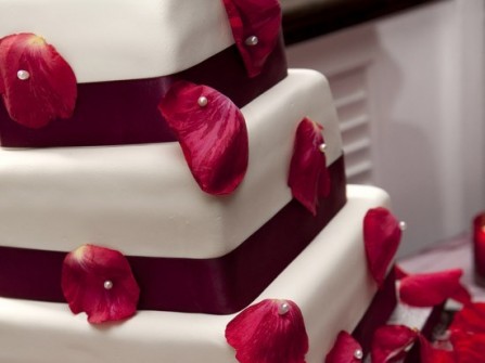 Bánh cưới màu đỏ đính với cánh hoa hồng