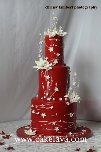 Bánh cưới tròn màu đỏ trang trí hoa dây trắng